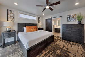 Bedroom with recessed lighting, a barn door, ceiling fan, and ensuite bath
