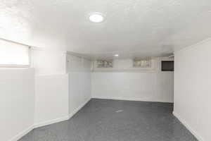 Below grade area with baseboards and a textured ceiling