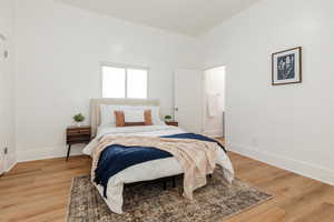 Bedroom with light wood finished floors and ensuite bath