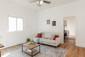 Living room with light wood-type flooring and a ceiling fan