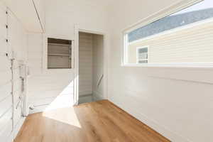 Empty room with light wood-style flooring and wooden walls