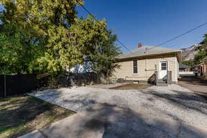 Rear view of house with a patio, a chimney, a fenced backyard, and a mountain view