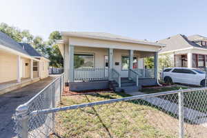 View of front of home with a porch, a fenced front yard, and a gate