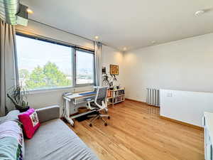 Office space featuring recessed lighting, light wood-style flooring, and radiator heating unit