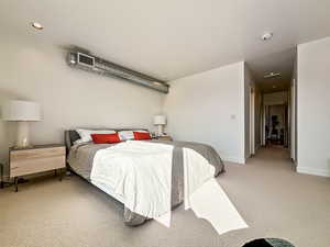 Bedroom with light colored carpet and recessed lighting