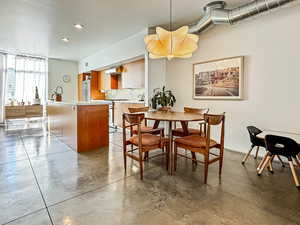 Dining room featuring finished concrete flooring and recessed lighting