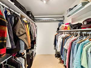 Walk in closet with light colored carpet