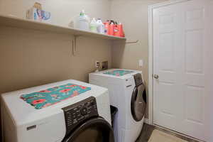 Laundry area featuring independent washer and dryer and wood finished floors