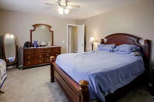 Carpeted bedroom featuring ceiling fan and baseboards