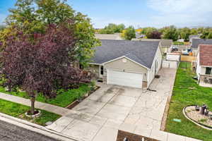 View of front of home featuring roof with shingles, concrete driveway, a garage, and brick siding