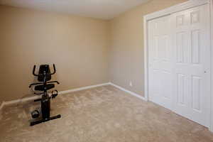 Exercise area featuring carpet and a textured ceiling