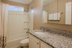 Full bathroom featuring shower / bath combo with shower curtain and vanity