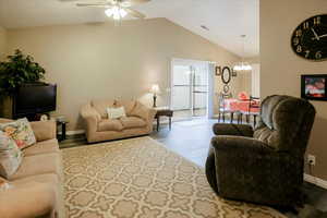 Living area featuring lofted ceiling, a ceiling fan, wood finished floors, and a chandelier