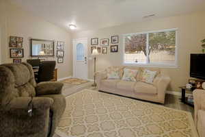 Living area with wood finished floors and vaulted ceiling