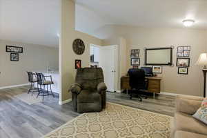 Office space featuring lofted ceiling and light wood-type flooring