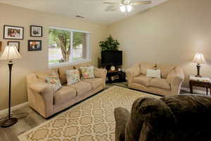 Living area with wood finished floors, lofted ceiling, and ceiling fan