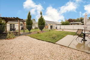 Fenced backyard with a patio area, a residential view, and a pergola