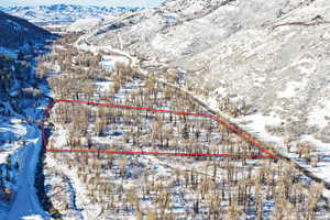 Snowy aerial view featuring property boundaries highlighted and a mountain view