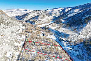 Snowy aerial view featuring property boundaries highlighted and a mountain view