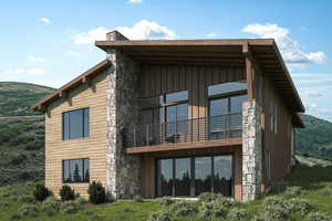 Rear view of property with stone siding, a balcony, a mountain view, and board and batten siding