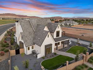 View of front facade with a fenced backyard, a porch, stucco siding, a gate, and a mountain view