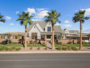 View of front of house with a fenced front yard, brick siding, covered porch, and a mountain view