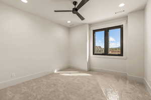 Carpeted spare room with a ceiling fan and recessed lighting