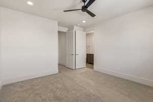 Unfurnished bedroom featuring recessed lighting, connected bathroom, light colored carpet, and a ceiling fan
