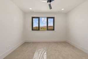 Spare room featuring light colored carpet, a ceiling fan, and recessed lighting