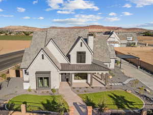 View of front facade with a fenced front yard, a mountain view, a shingled roof, brick siding, and a chimney