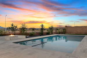 View of pool featuring a fenced backyard, a patio, and a fire pit