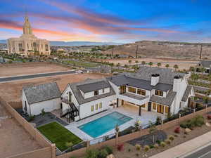 Back of house at dusk featuring a fenced backyard, a patio area, a metal roof, a standing seam roof, and stucco siding