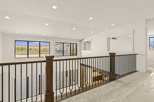 Hallway with healthy amount of natural light, carpet, recessed lighting, and vaulted ceiling