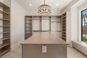 Spacious closet featuring light carpet and a chandelier
