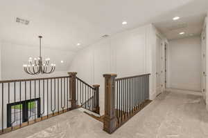 Corridor with lofted ceiling, recessed lighting, carpet floors, a chandelier, and an upstairs landing