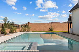 View of pool featuring a fenced backyard, a patio, and a pool with connected hot tub