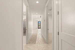 Hallway with recessed lighting and baseboards