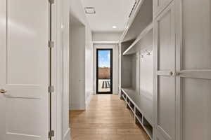 Mudroom with light wood finished floors and baseboards