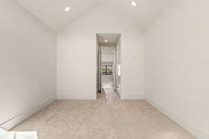 Spare room with light carpet, recessed lighting, and vaulted ceiling