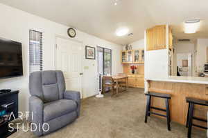 Living area featuring lofted ceiling and light colored carpet