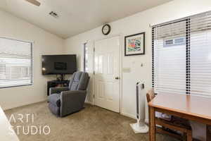 Living area with vaulted ceiling, carpet, and ceiling fan
