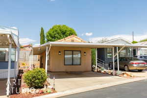 View of front of home featuring stucco siding and a carport