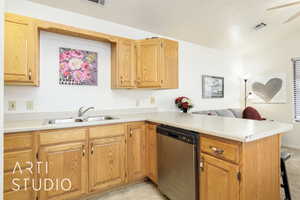 Kitchen with light countertops, stainless steel dishwasher, a peninsula, a kitchen bar, and lofted ceiling