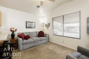 Living area with light carpet, lofted ceiling, and a ceiling fan