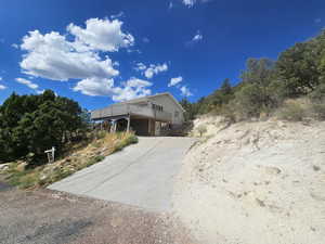 View of front of home featuring concrete driveway and a wooden deck