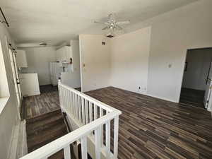 Staircase with wood finished floors, a barn door, and a ceiling fan