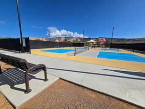 View of home's community featuring a tennis court and a patio area