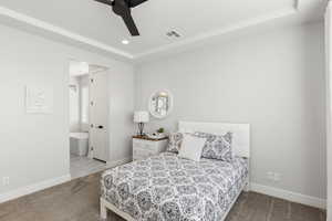 Bedroom with light colored carpet, a raised ceiling, ceiling fan, ensuite bathroom, and recessed lighting