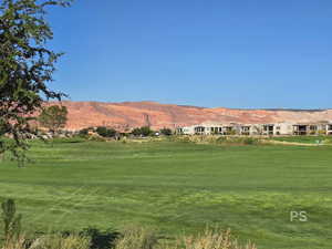 View of property's community with a mountain view, golf course view, and a yard