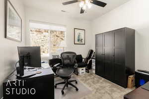 Office with light carpet and ceiling fan